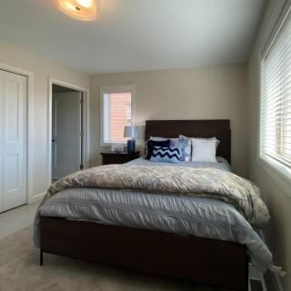 A cozy bedroom with a neatly made bed and decorative pillows.