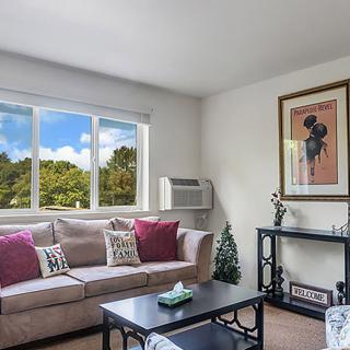 A cozy living room with a large window, comfortable sofa, and stylish decor.