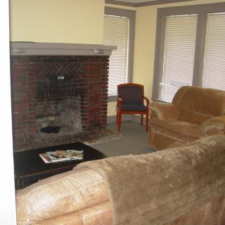 A cozy living room with a brick fireplace, sofas, and a coffee table.