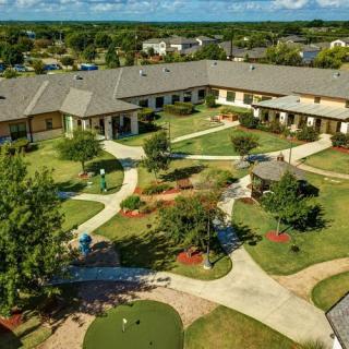 Aerial view of a landscaped residential complex with pathways and gardens.