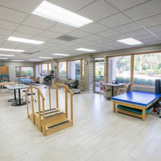 A bright and spacious rehabilitation therapy room equipped with various exercise tools.