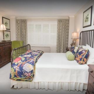 A well-decorated bedroom with a comfortable bed, colorful pillows, and stylish decor.