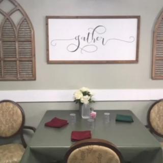 A cozy dining area with a decorated table and wall art emphasizing the theme of gathering.
