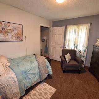A cozy and inviting bedroom featuring soft furnishings and decorative elements.