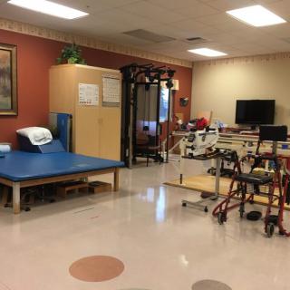A rehabilitation room equipped with various physical therapy tools and exercise equipment.