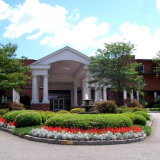 A beautiful hotel entrance surrounded by vibrant flowers and lush greenery.