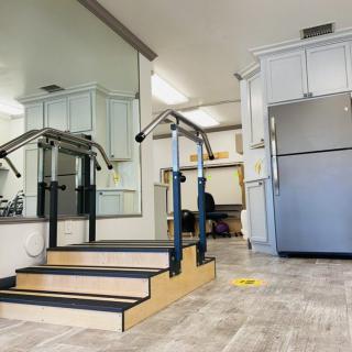 A rehabilitation facility featuring a set of stairs with handrails for physical therapy exercises.