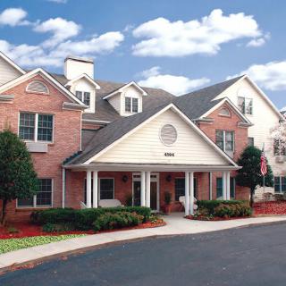 A suburban residential building with a brick facade and gabled roof.