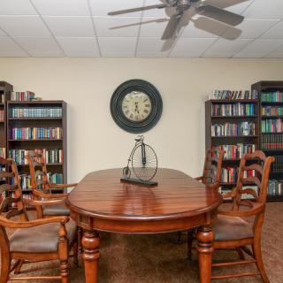 A cozy library meeting room with wooden furniture and bookshelves filled with books.