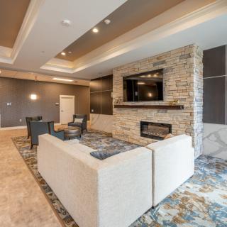 A modern living room featuring a cozy seating area with a sofa, a fireplace, and a mounted television.