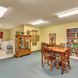 A cozy living room with a dining table, bookshelf, and a display cabinet.