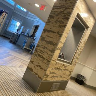 A modern lobby featuring a stylish marble column and contemporary furnishings.