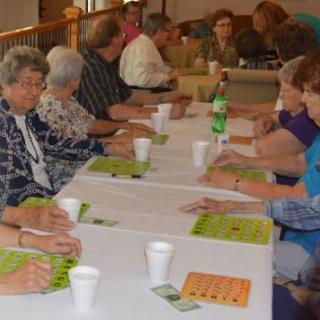 A group of people playing bingo at an indoor event.