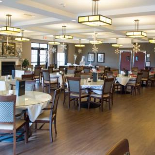 A spacious and elegantly designed dining area with neatly arranged tables and chairs.