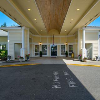 Entrance of a building with a covered driveway and designated fire lane.