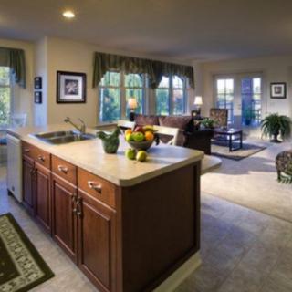 A cozy open floor plan combining kitchen and living room spaces, featuring a central island and large windows.