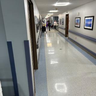 A view of a hospital hallway with artwork displayed on the walls.