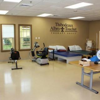 A rehabilitation center with therapy beds and exercise equipment.