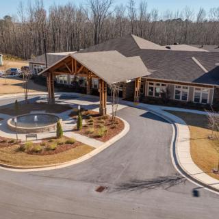 Aerial view of a building with a circular driveway and landscaped entrance.