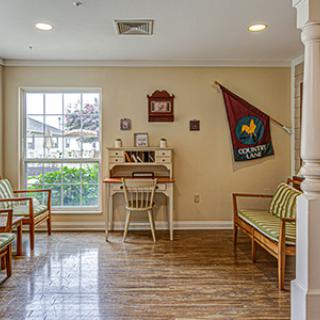 A cozy waiting room with a desk and chairs, decorated with a flag and other decor items.