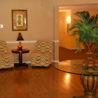 A cozy lobby area with comfortable seating, plants, and warm lighting.