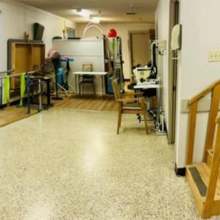 A physical therapy room equipped with parallel bars and rehabilitation equipment.