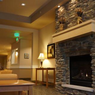 A cozy lobby area featuring a stone fireplace and comfortable seating, illuminated by warm lighting.