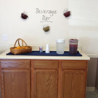 A cozy beverage bar setup featuring various drink containers and decorative elements.