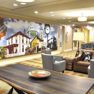 A modern lobby featuring a vibrant mural and cozy seating area.
