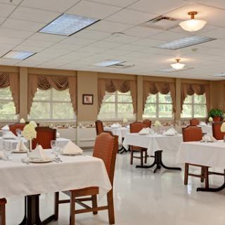 A spacious and elegantly arranged dining room with neatly set tables, ready for guests.