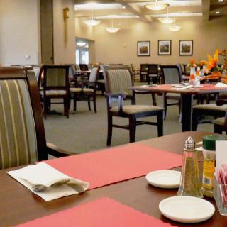 An empty restaurant dining room with neatly arranged tables and chairs.
