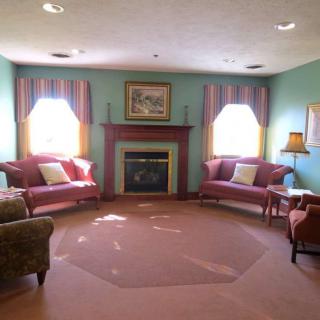 A cozy living room with a fireplace, couches, and traditional decor.
