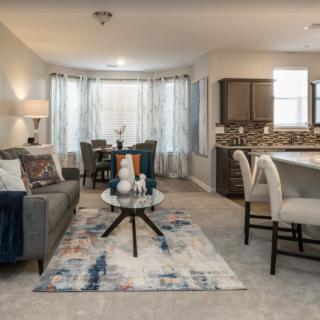 A stylish open-plan living and dining area with modern furniture and neutral tones.