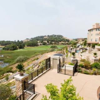 A scenic view of a luxury building overlooking a sprawling golf course.