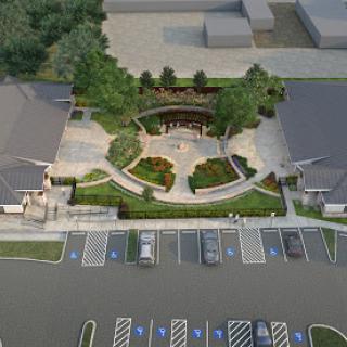 Aerial view of a landscaped area with buildings and a parking lot.
