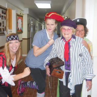 A group of people having fun dressed in pirate costumes indoors.