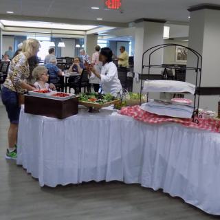 People gathering around a buffet table in an indoor setting.