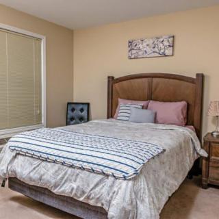 A cozy bedroom with a neatly made bed and tasteful decor.