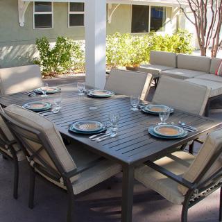 An outdoor patio dining set with a table and chairs arranged for a meal.