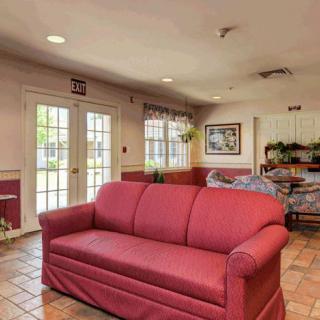 A cozy living room with a red sofa and natural lighting from large windows.