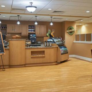 An empty cafe interior with a wooden counter and display case.