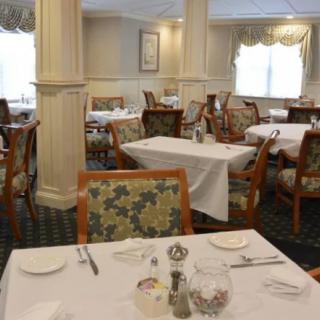 An elegant dining area with neatly set tables and upholstered chairs.
