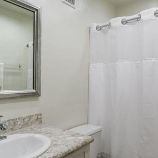 A clean and simple bathroom with a marble countertop and a shower curtain.