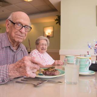 An elderly couple enjoying a meal together at a restaurant.