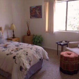 A cozy bedroom with a single bed, a window, and comfortable decor.