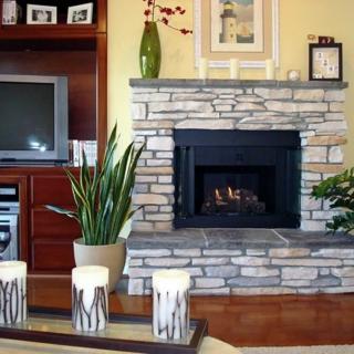 A cozy living room with a stone fireplace and decorative elements.
