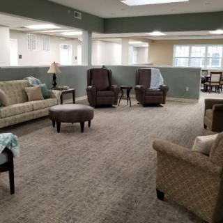 A cozy living room with comfortable seating and a carpeted floor.