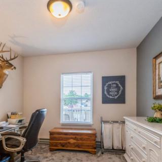A cozy home office with a desk, chair, and decorative elements.