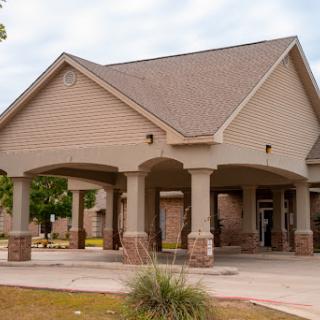 A modern residential building featuring a spacious porch and stone accents.