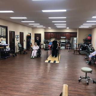 A physical therapy session in progress at a rehabilitation center, featuring patients participating in various exercises.